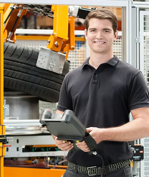 Servicemitarbeiter von Schenck vor einer Schenck Auswuchtmaschine mit Auslesegerät in der Hand